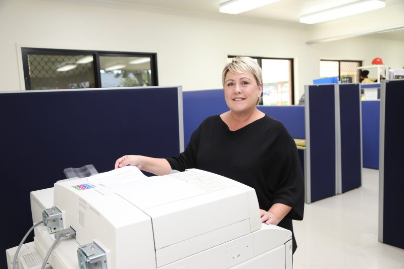 Image of a woman using a photocopier in an office