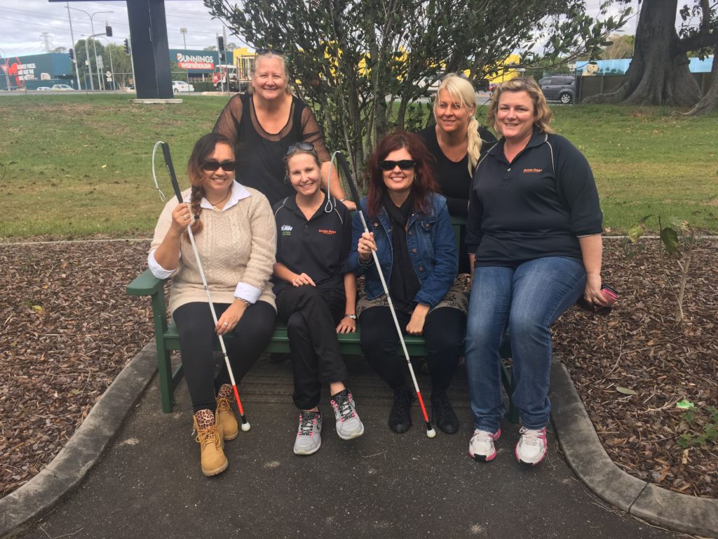 Image of four women and two Guide Dogs Instructors sitting on a park bench