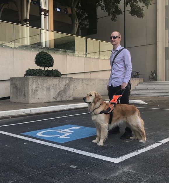 Rhett Bryant with his Guide Dog Jeffrey, advocating for blind and vision impaired Queenslanders to be eligible for Disabilty Parking Permits.