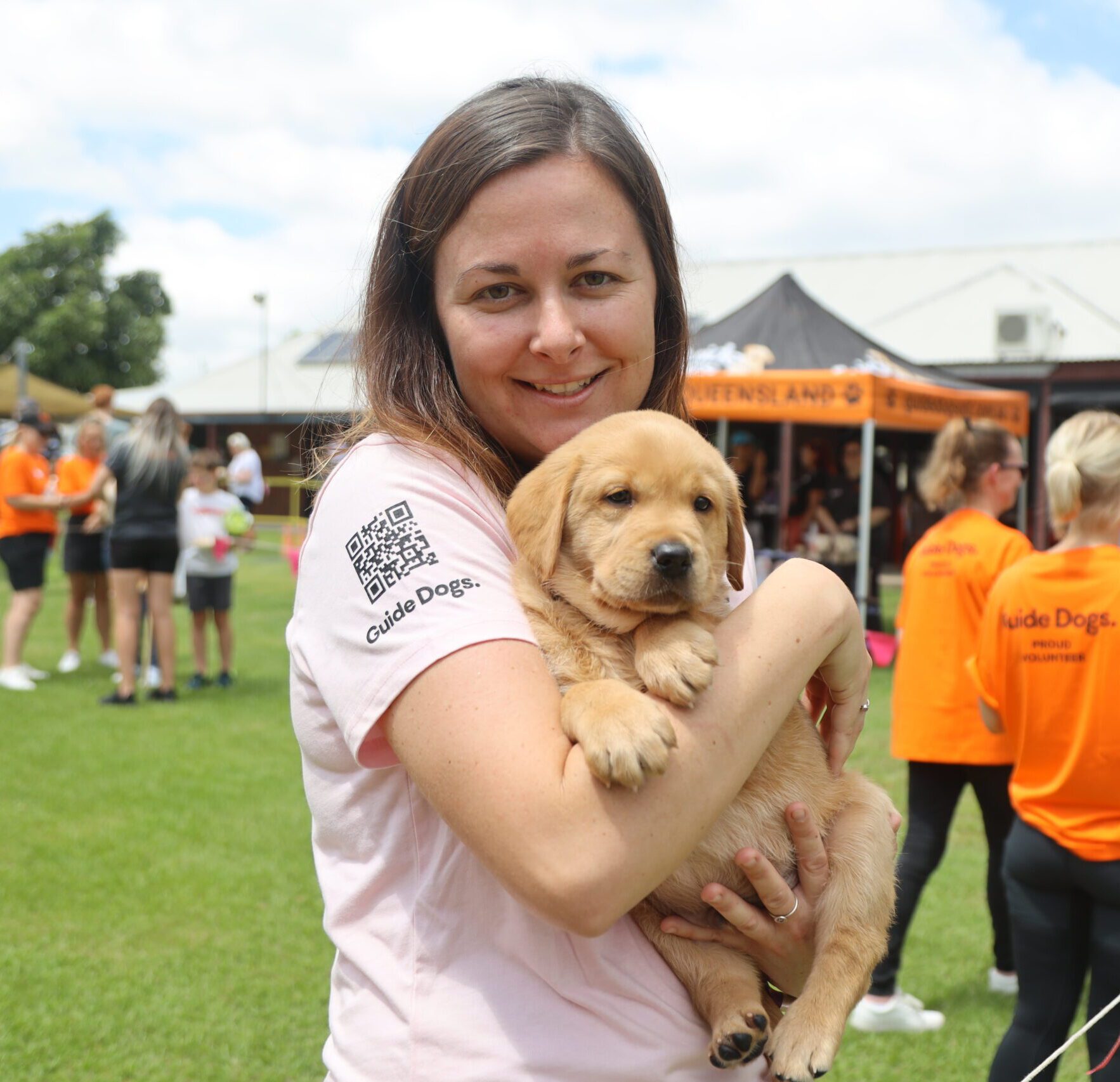 Woman holding a yellow labrador puppy