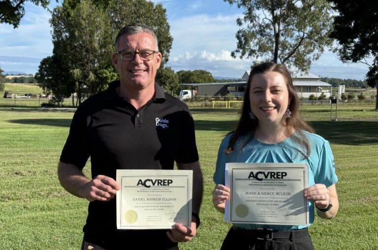 Daniel Ellison and Jessica McLeod proudly hold their COMS certificates outdoors after completing their Certified Orientation and Mobility Specialist training.