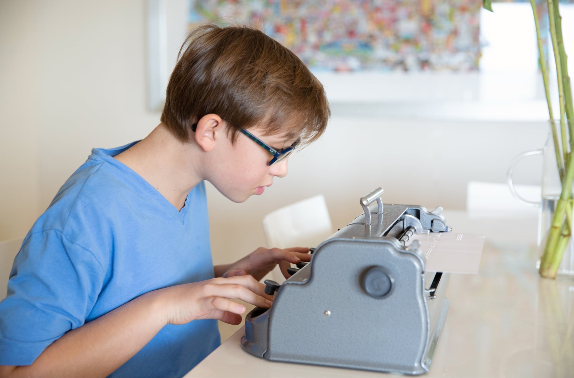 A young child using a braille machine.