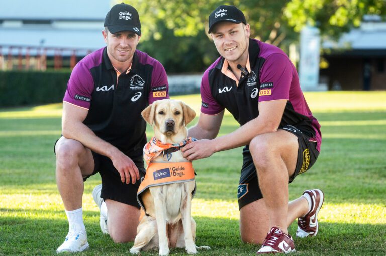 Two Broncos players with puppies