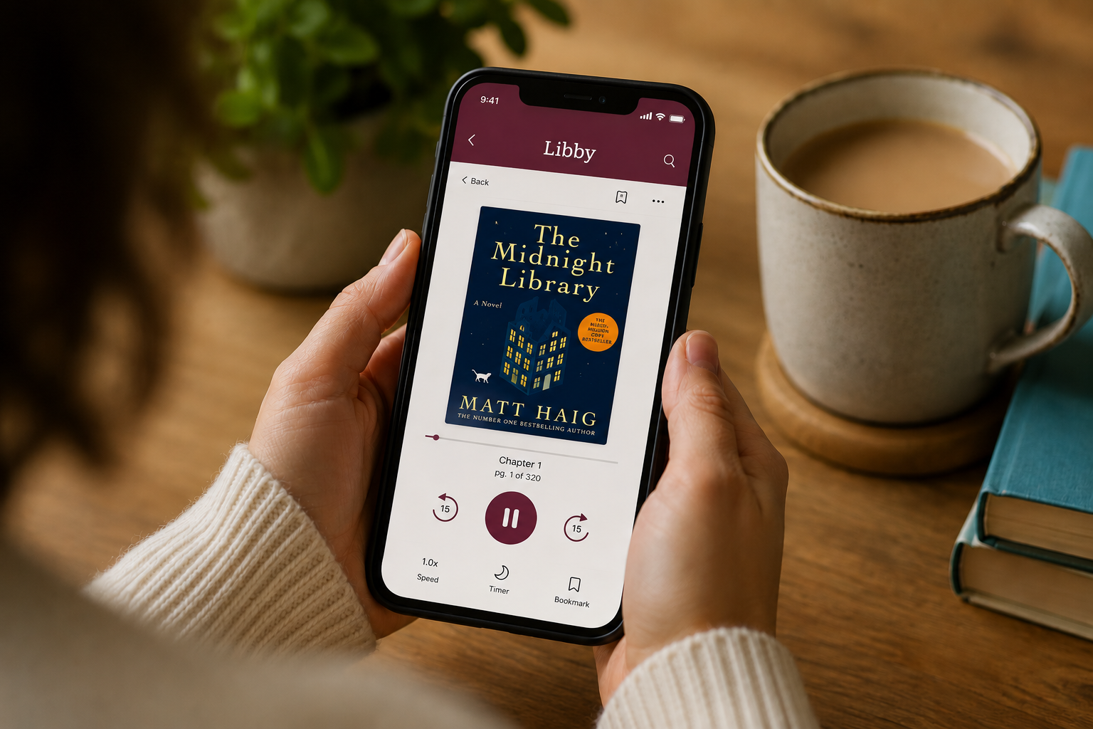 A person holds a smartphone displaying the Libby app e-reader interface, showing the book cover of 