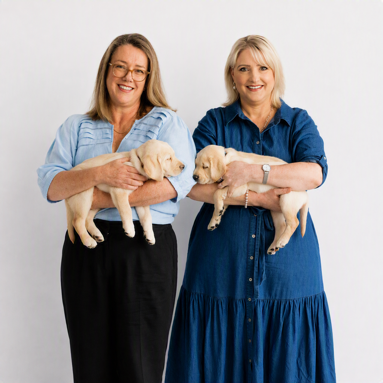 Liz and Corinne from the Gift in Wills team. Each holding a puppy.