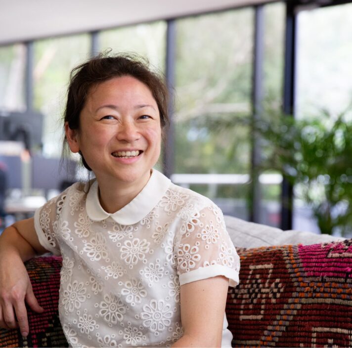 A person sitting in a cafe smiling at the camera.