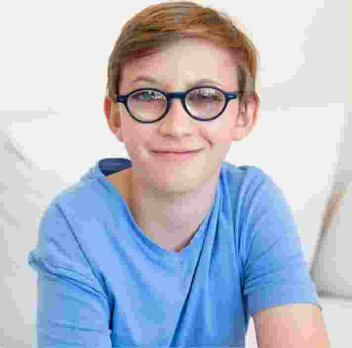 A young child looking at the camera smiling.